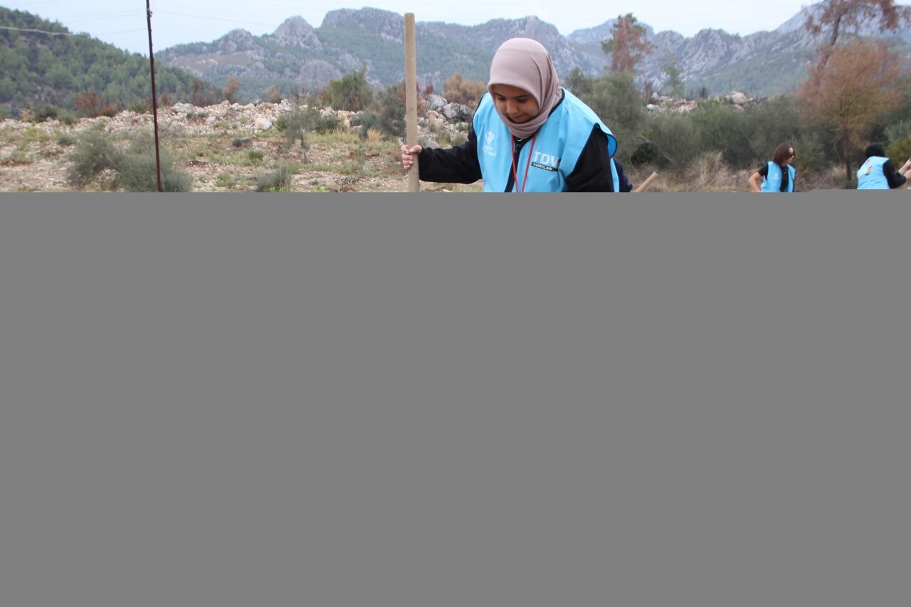 Antalya'da kız öğrenciler, yangından zarar gören bahçeye fidan dikti