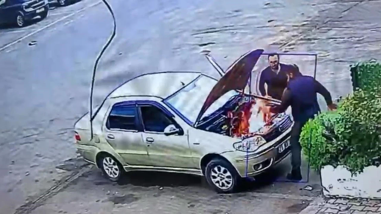 Alev alan otomobili üfleyerek söndürmeye çalıştı: O anlar kamerada