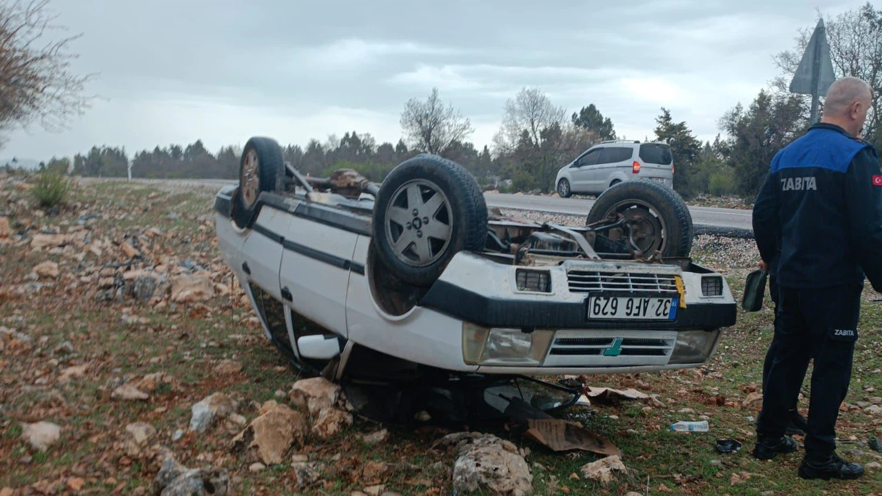 Araziye devrilen otomobilden yara almadan çıktılar