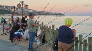 Akşam serinliğinde iskelede buluşan amatör balıkçılar keyifli anlar yaşıyor
