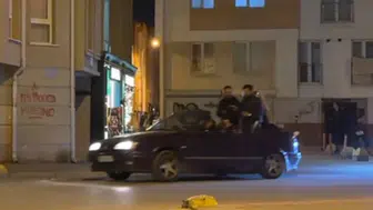 Seyir halindeki otomobilin bagajına oturan şahıs dikkat çekti