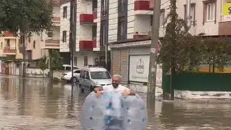 Tarsus'ta sağanak yağış yolları göle çevirdi: Muhtar öğrenciyi kucağında taşıdı