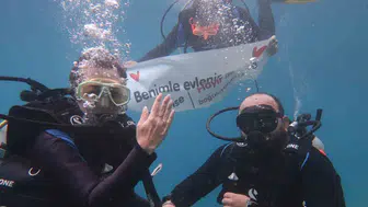 Deniz altında pankart açtı, şaşkına çevirdi! Fethiye'de filmleri aratmadı
