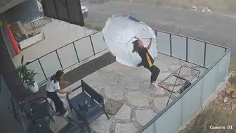 Fırtına karşısında genç kızların şemsiye mücadelesi güvenlik kamerasında
