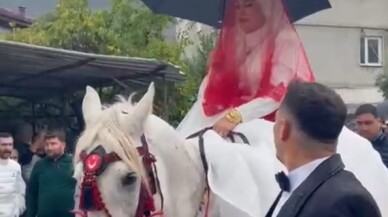 Düğününde ata binen gelin, yağış altında şemsiyeyle tur attı