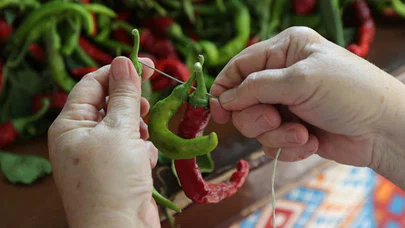 Tava ciğerin lezzet yoldaşı Karaağaç acı biberi "dantel örer" gibi ipe diziliyor