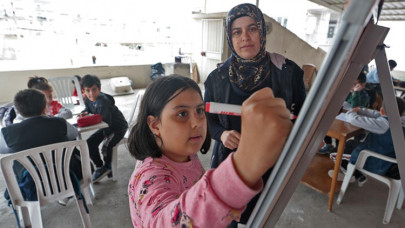 Enkazdan kurtulan Sibel öğretmen terasta hazırladığı sınıfta öğrencilere eğitim veriyor