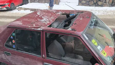 Kars’ta bina çatılarındaki tehlike bir kez daha gündemde... Aracını park eden sürücü hastanelik oldu!
