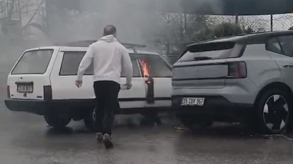 Yanan otomobile yol kenarındaki su birikintisinden doldurduğu kovayla müdahale etti