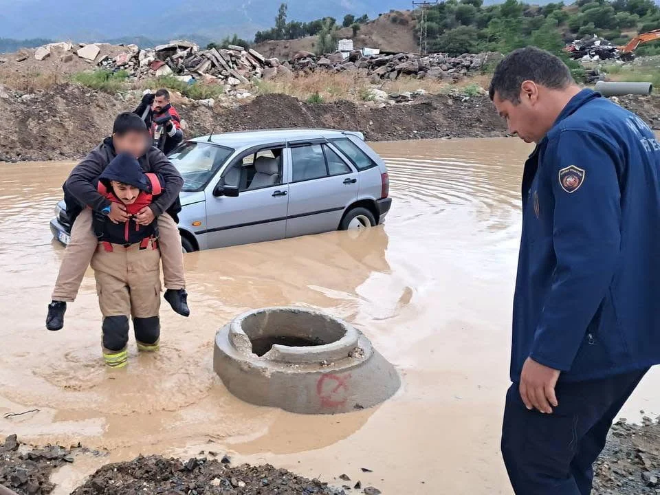 HATAY'DA İTFAİYE PERSONELİ, ETKİLİ OLAN YAĞIŞLA BİRLİKTE GÖLE DÖNEN YOLDA MAHSUR KALAN ARAÇ...