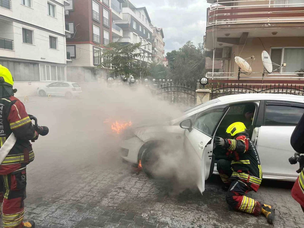 BALIKESİR’İN BURHANİYE İLÇESİNDE CADDE ÜZERİNDE ANİDEN ALEV ALAN OTOMOBİL, İTFAİYE EKİPLERİNİN...